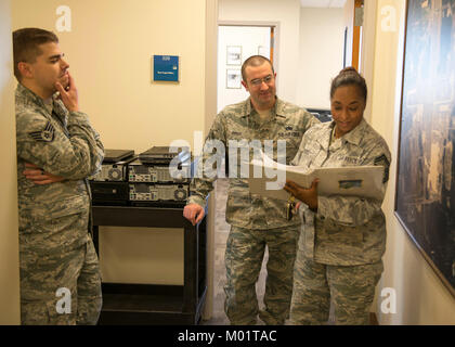 Staff Sgt. Michael Servis und Technischen Sgt. Andrew Perry der 102 Intelligenz Flügel Communications Flug unterstützen Senior Master Sgt. Andrea Burgo installieren Sie neue Computer in der Befehl Gebäude am Otis Air National Guard Base, Joint Base Cape Cod, Massachusetts. Stockfoto