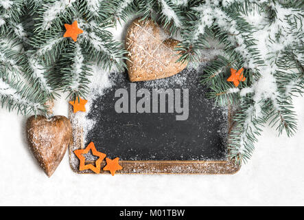 Schwarz schwarzes Brett unter den Weihnachtsbaum Zweige mit Schnee bedeckt, text Raum Stockfoto