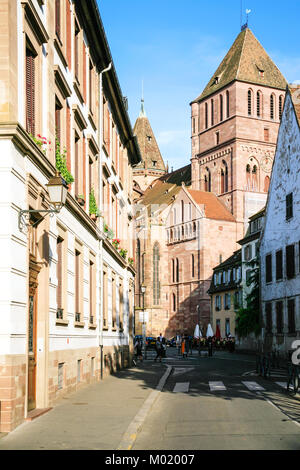 Straßburg, Frankreich - 11. JULI 2010: Menschen auf der Straße Rue de la Monnaie und Blick auf die St. Thomas Kirche in Straßburg. Straßburg ist die Hauptstadt der Grand Stockfoto