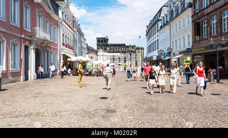 TRIER, Deutschland - 28. JUNI 2010: Menschen auf simeonstrasse Street und Blick auf den alten römischen Monument Porta Nigra (Schwarze Tor) in Trier Stadt. Die Porta Ni Stockfoto