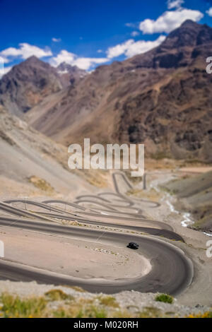 Auto fahren bergauf auf der Drehen und Drehen gewundener Straße durch hohen Anden in Chile, Südamerika Stockfoto