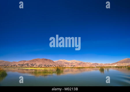 Puno Stadt wie aus dem ruhigen Wasser des Titicacasees in Peru, Südamerika gesehen Stockfoto