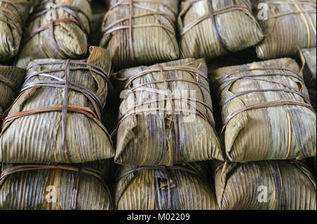 Hausgemachte köstliche chinesische Reisknödel in Bambusblatt gewickelt. Stockfoto