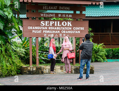 Malaysische Familie vor der Sepilok Rehabilitation Centre, Borneo, Sabah, Malaysia posing Stockfoto