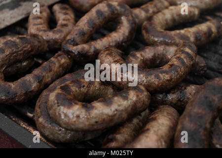 Frische, hausgemachte Wurst auf dem Grill im Freien. Fast food Fleisch. Elektrischer Grill. Gefüllte Wurst für das Grillen. Fast food. Stockfoto