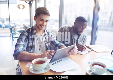 Attraktive männliche Person halten Lächeln auf seinem Gesicht Stockfoto