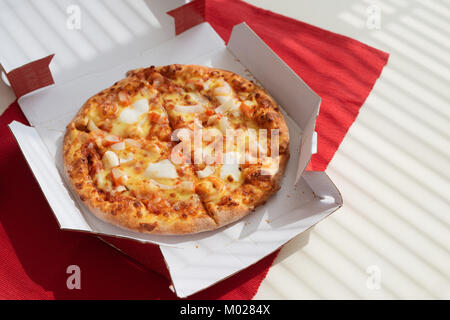 Pizza in einem Karton auf weißer Tisch. Pizza Delivery. Pizza Menü. Stockfoto