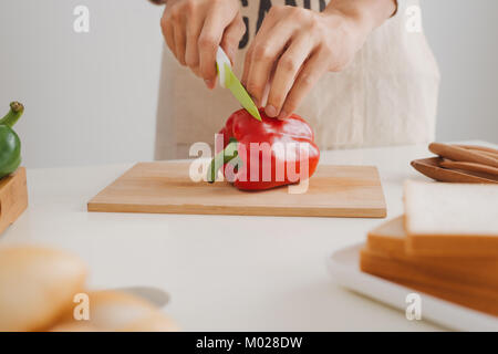 Männliche Hände schneiden Frische rote Paprika Stockfoto