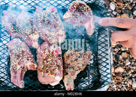 Reisen nach Frankreich - Kochen fast food Lammfleisch in tragbaren Einweggrill auf p Strand Plage de la Baie de Launay in Paimpol Region Bretagne Stockfoto