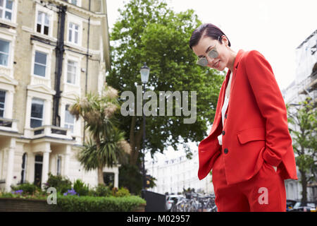 Schicke Frau in Rot Anzug in Notting Hill Street, horizontal Stockfoto