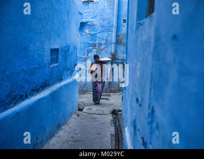 Frau Tragen einer Last in die blaue Stadt Jodhpur, Rajasthan, Indien Stockfoto