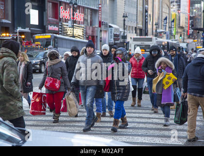 Menschen an einem kalten Wintertag kreuz Broadway an der 34th Street in der Nähe von Macy's in Manhattan gebündelt. Stockfoto