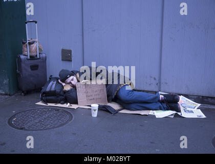 Jungen obdachlosen Mann schläft am Broadway entlang mit einem Schild um Hilfe zu bitten, in den Stadtteil Manhattan. NYC. Stockfoto