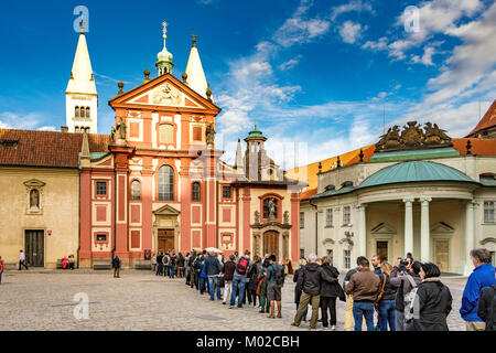 Touristen und Besucher stehen Schlange, um die St.-Georgs-Basilika im Komplex der Prager Burg, Prag, Tschechische Republik, zu betreten Stockfoto