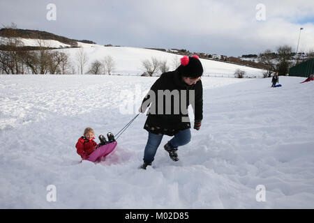 Fünf Jahre alten Dani Paterson mit Mutter Sally Rodeln im Schnee in Selkirk als Polizei drängt Autofahrer sind mit "extreme Vorsicht" unter winterlichen Bedingungen in Schottland zu fahren. Stockfoto