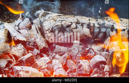 Helles Feuer in Metall brazier. Viele lange Holz befeuert. Holz Brennen in der brazier. Flammen Feuer. Vorbereitung für das Kochen Grill Stockfoto