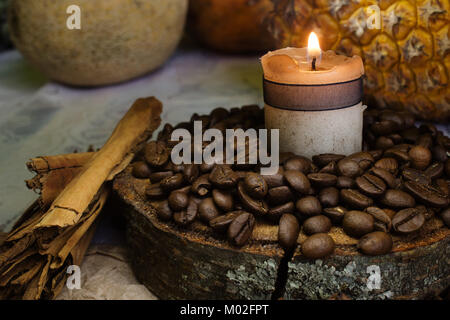 Kaffeebohnen auf rustikalen, mit Holz, eine Kerze und Stick von Zimt, Ananas auf Hintergrund Stockfoto