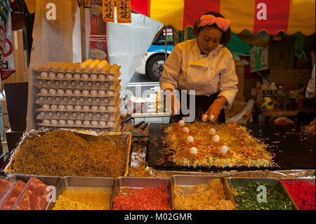 31.12.2017, Tokyo, Japan, Asien - eine Frau bereitet frisch gerösteten Pfannkuchen auf einer Straße in Tokios Stadtteil Shibuya abgewürgt. Stockfoto