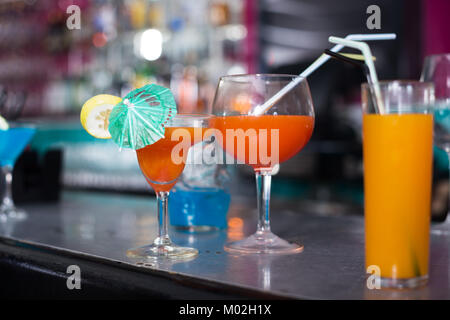 Fotografie von leckeren Cocktails mit Strohhalmen auf Theke Stockfoto