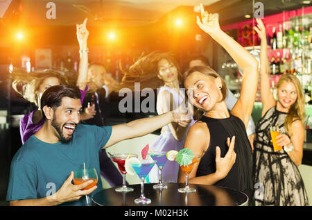 Junge Frau mit Mann tanzen und trinken Cocktail auf der Party in der Bar Stockfoto