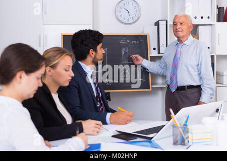 Alten Chef ist die Einführung von Untergebenen in Projekt auf der Sitzung im Büro. Stockfoto