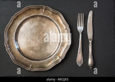 Leere vintage Metallplatte mit Besteck auf Schwarz, mit Kopie Raum für Ihr Menü oder ein Rezept. Menü Karte für Restaurants. Tabelle plase Einstellung. Stockfoto