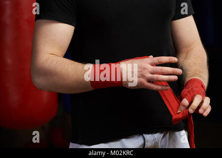 Kaukasische Mann gelten Hand bandage Nähe zu sehen. Sportman vor dem Kampf Stockfoto