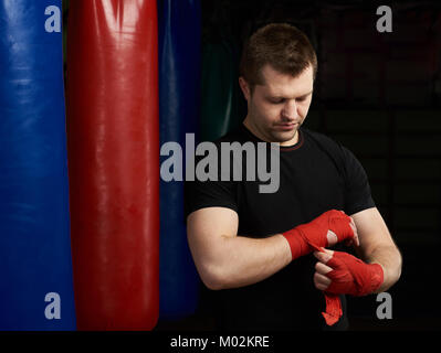 Boxing Mann und von Hand Bandage auf modernen Fitnessraum Hintergrund Stockfoto