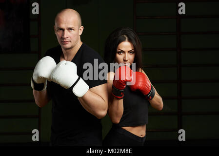 Boxing Unterricht Konzept. Junge Frau und Mann halten sie Hände oben in Boxhandschuhe Stockfoto