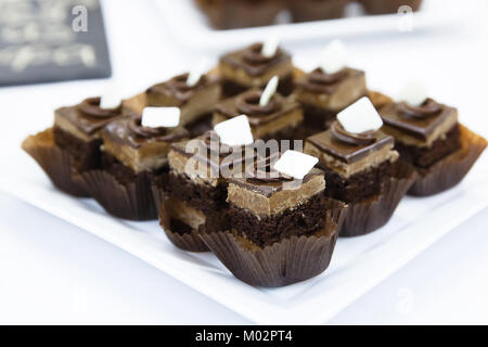 Gastronomie Miniatur Schokolade baiser Kuchen mit Sahne und Mandeln auf weißen Tisch Stockfoto