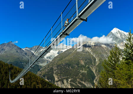 Wanderer auf dem Charles Kuonen Suspension Bridge, den weltweit gro§ten Erdolforderlandern zahlt längste Hängebrücke, mit dem Weisshorn Peak im Hintergrund, Randa, Kanton Va Stockfoto