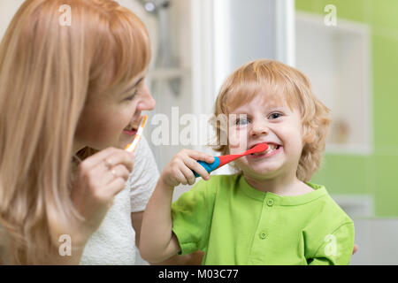 Mutter lehrt ihr Kind Sohn wie Zähne putzen Stockfoto