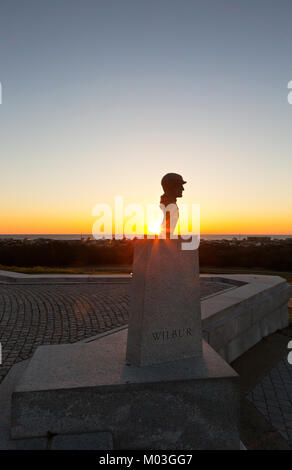 NC-01338-00... NORTH CAROLINA - Sonnenaufgang über dem Atlantik hinter der Büste von Wilbur Wright an der Basis der Denkmal an die Brüder Wright Nati Stockfoto