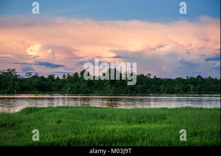 Sonnenuntergang auf dem Fluss tief in den Regenwäldern in Neuguinea Insel. Fluss, Sonnenuntergang Wolken und Regen Wald Urwald. Neuguinea Insel Stockfoto