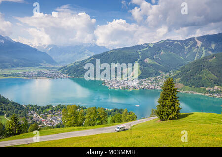 Panoramablick über die schöne Landschaft der Alpen mit klaren See und grüne Wiesen voller blühender Blumen an einem sonnigen Tag mit blauen Himmel und Wolken Stockfoto