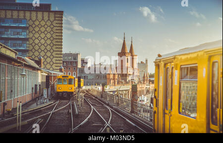 Panoramablick auf die Berliner U-Bahn mit der oberbaum Bridge im Hintergrund im goldenen Abendlicht bei Sonnenuntergang mit Retro Vintage Instagram Style Hüfthose Stockfoto