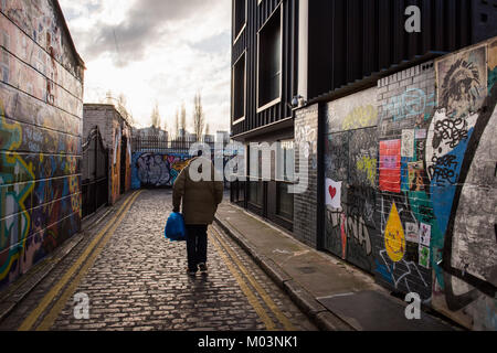 Mann alleine entlang Grimsby Straße, Brick Lane, East London, Großbritannien Stockfoto