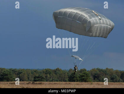 Fallschirm Vordächer füllen Sie den Himmel als Fallschirmjäger aus acht Ländern Land am Houtdorperveld Drop Zone während Falcon Sprung Sept. 15, 2017, Valkenburg, Niederlande. (U.S. Air Force Stockfoto