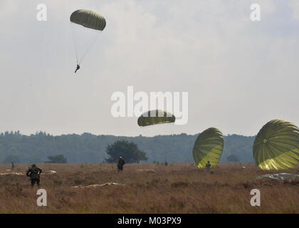 Fallschirm Vordächer füllen Sie den Himmel als Fallschirmjäger aus acht Ländern Land am Houtdorperveld Drop Zone während Falcon Sprung Sept. 15, 2017, Valkenburg, Niederlande. (U.S. Air Force Stockfoto