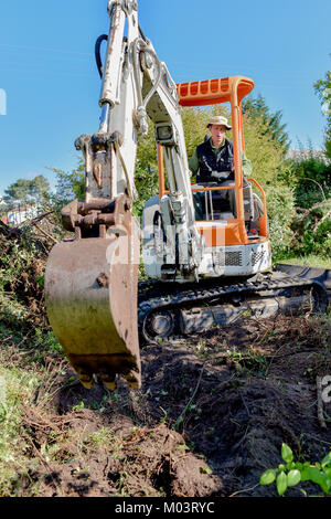 Mann mit einem Bagger in den Garten Stockfoto