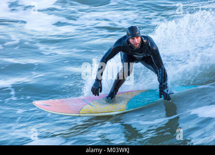 Bournemouth, Dorset, Großbritannien. 18 Jan, 2018. UK Wetter: Nach einer sehr windigen Nacht ein schöner sonniger Tag am Strand von Bournemouth. Surfer nutzen die großen Wellen und choppy Meeren. Surfer auf einer Welle. Credit: Carolyn Jenkins/Alamy leben Nachrichten Stockfoto