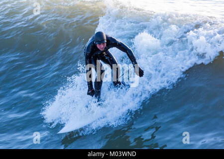 Bournemouth, Dorset, Großbritannien. 18 Jan, 2018. UK Wetter: Nach einer sehr windigen Nacht ein schöner sonniger Tag am Strand von Bournemouth. Surfer nutzen die großen Wellen und choppy Meeren. Surfer auf einer Welle. Credit: Carolyn Jenkins/Alamy leben Nachrichten Stockfoto