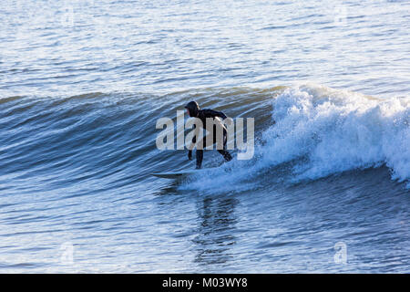 Bournemouth, Dorset, Großbritannien. 18 Jan, 2018. UK Wetter: Nach einer sehr windigen Nacht ein schöner sonniger Tag am Strand von Bournemouth. Surfer nutzen die großen Wellen und choppy Meeren. Surfer auf einer Welle. Credit: Carolyn Jenkins/Alamy leben Nachrichten Stockfoto