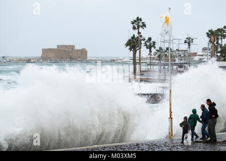 Paphos, Zypern. 18 Jan, 2018. Eine Gruppe von Menschen beobachten, wie große Wellen Teig direkt am Meer bei einem Sturm im Hafen von Paphos, Republik Zypern. Foto: Ian Rutherford/Alamy leben Nachrichten Stockfoto