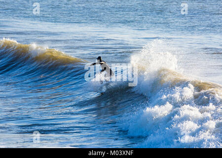 Bournemouth, Dorset, Großbritannien. 18 Jan, 2018. UK Wetter: Nach einer sehr windigen Nacht ein schöner sonniger Tag am Strand von Bournemouth. Surfer nutzen die großen Wellen und choppy Meeren. Surfer auf einer Welle. Credit: Carolyn Jenkins/Alamy leben Nachrichten Stockfoto