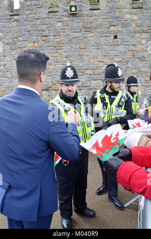 Das Schloss von Cardiff, Cardiff. 18/01/10. Mitglieder der Polizei austeilen Waliser Flags den Massen warten auf die Ankunft seiner Roual Hoheit Prinz Henry von Wales und Meghan Markle. Foto Bethanien Shorey Stockfoto