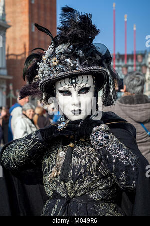 Venedig, Italien - 18. FEBRUAR 2017: vertikal orientierten Porträt einer unbekannten Frau tragen Vintage schwarz Kostüm, Handschuhe, Mütze und weiße Maske. Stockfoto