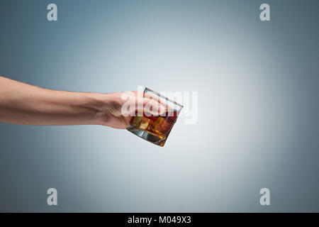 Hand mit einem Glas Whiskey Stockfoto