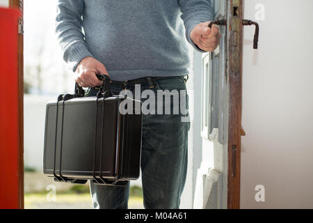 Ein Mann mit schwarzen Koffer nach Hause Stockfoto