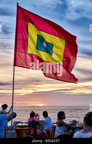 Wehende Flagge von Cartagena bei Sonnenuntergang am Cafe del Mar Stockfoto